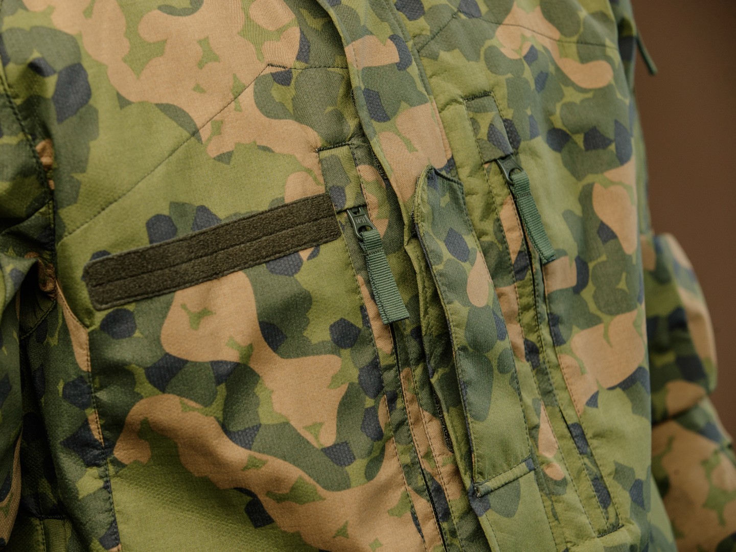 Uniformsjakke fra Forsvaret med kamuflasjemønster i grønne og beige toner.