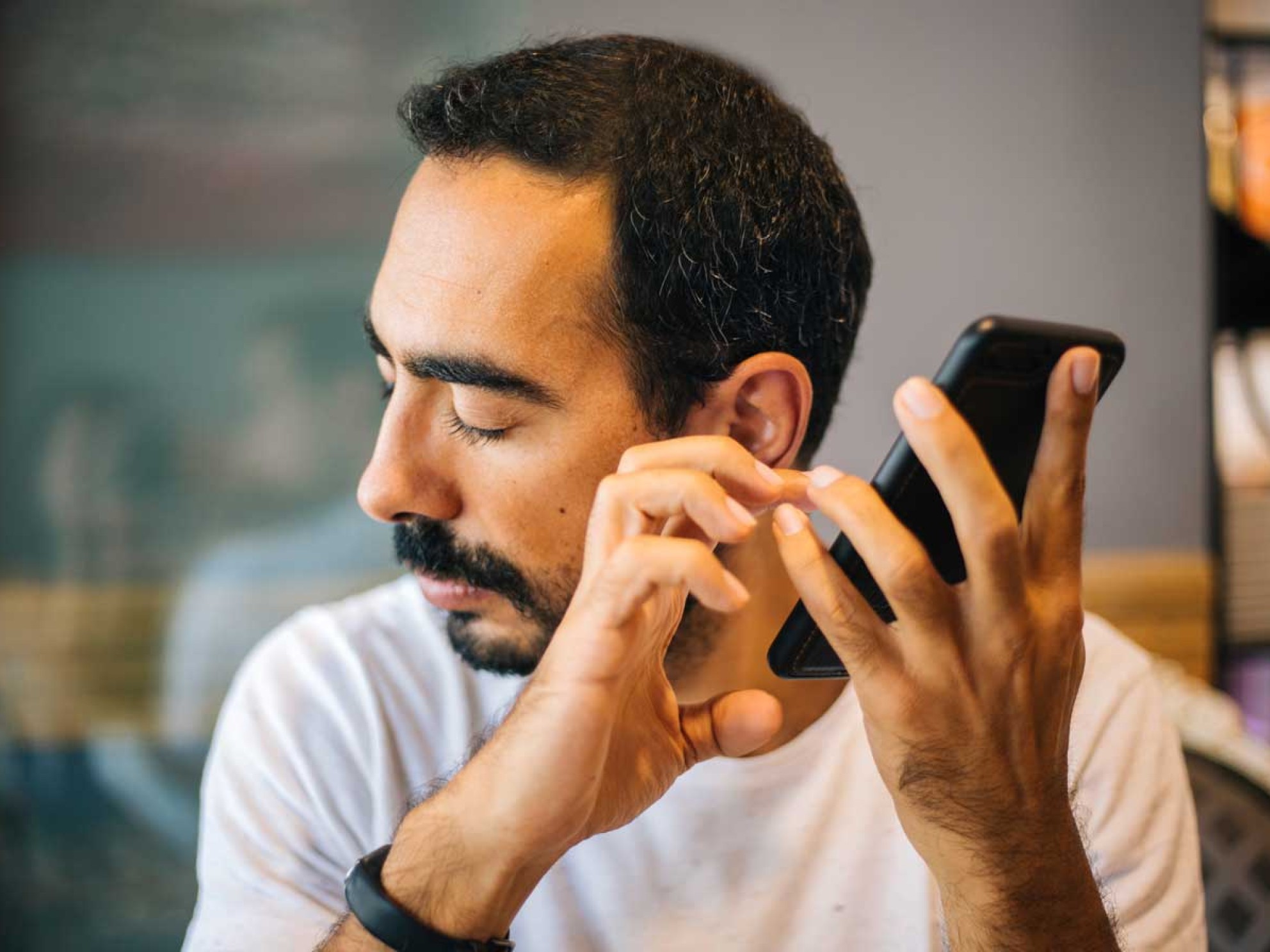 A visually impaired person listens to the mobile reading out a text.