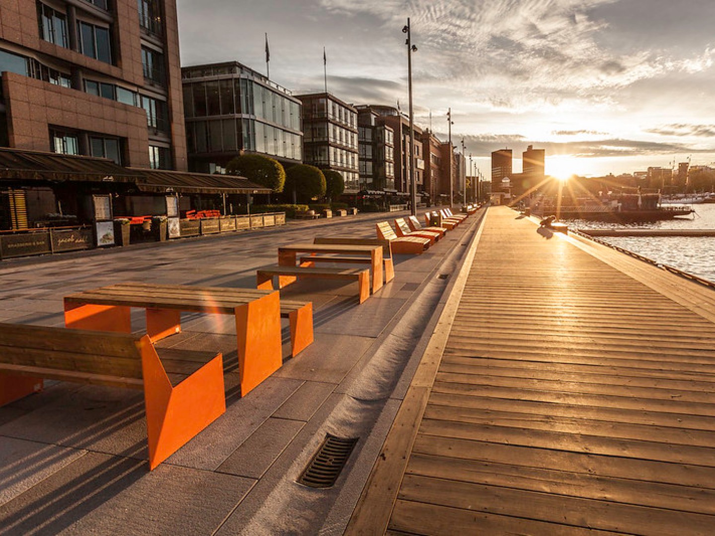 Vestre multi-purpose furniture at Aker Brygge with a view towards the town hall at sunset