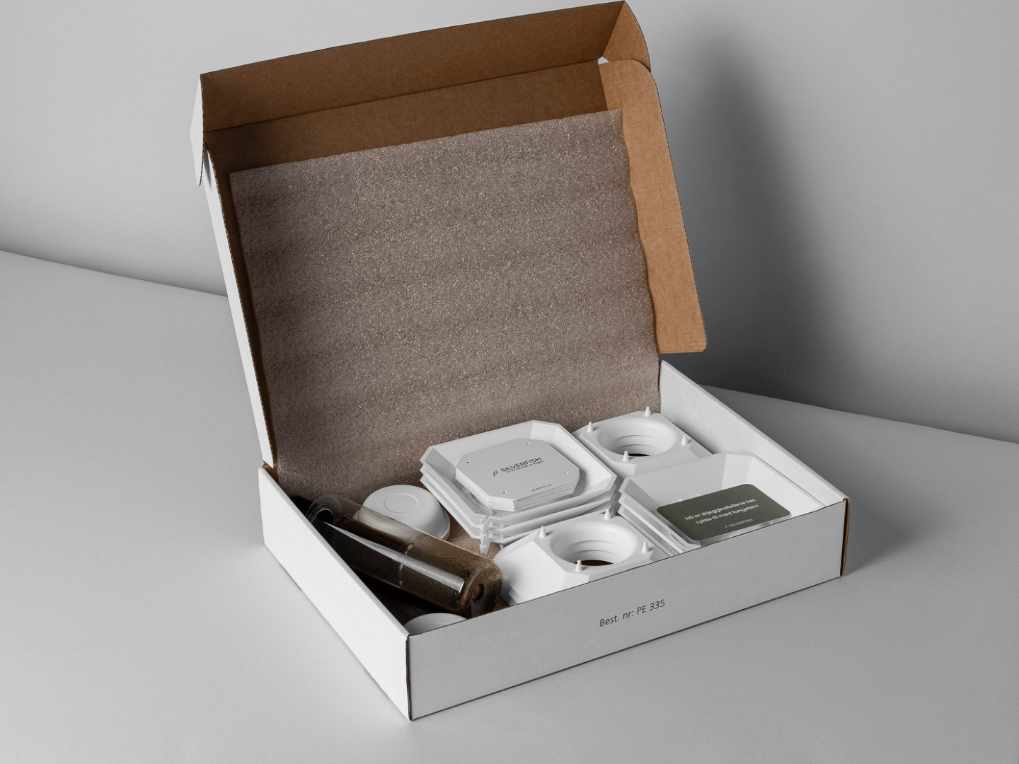 Box with plastic equipment and a bottle of fluid.