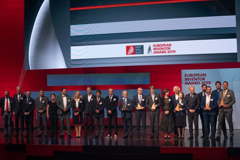 A number of people on a stage with the text European Inventor Award behind.