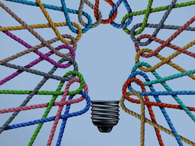 A light bulb is surrounded by many colored ropes.