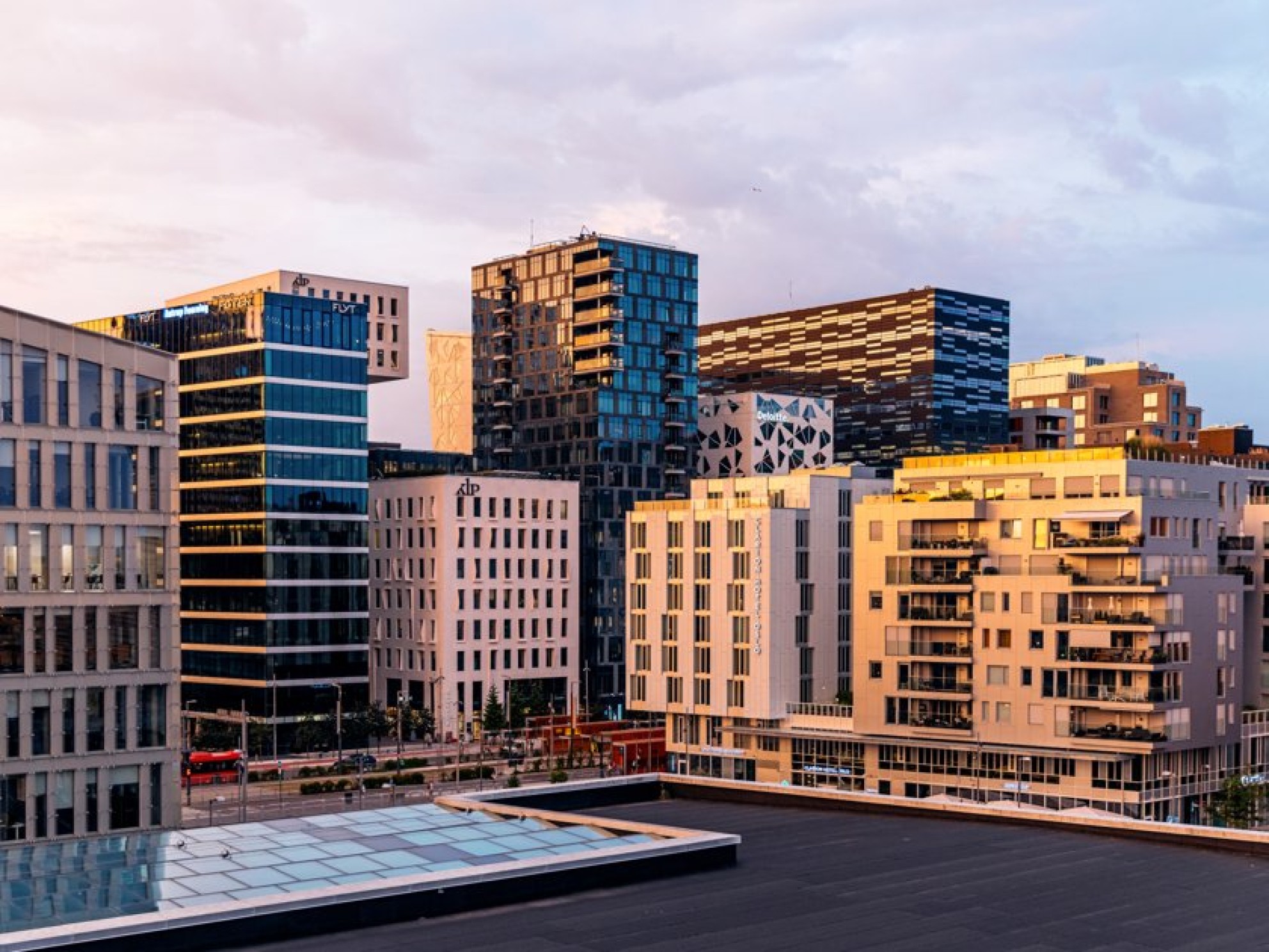 Landscape view of office buildings in Bjørvika where several company names are visible on the facade