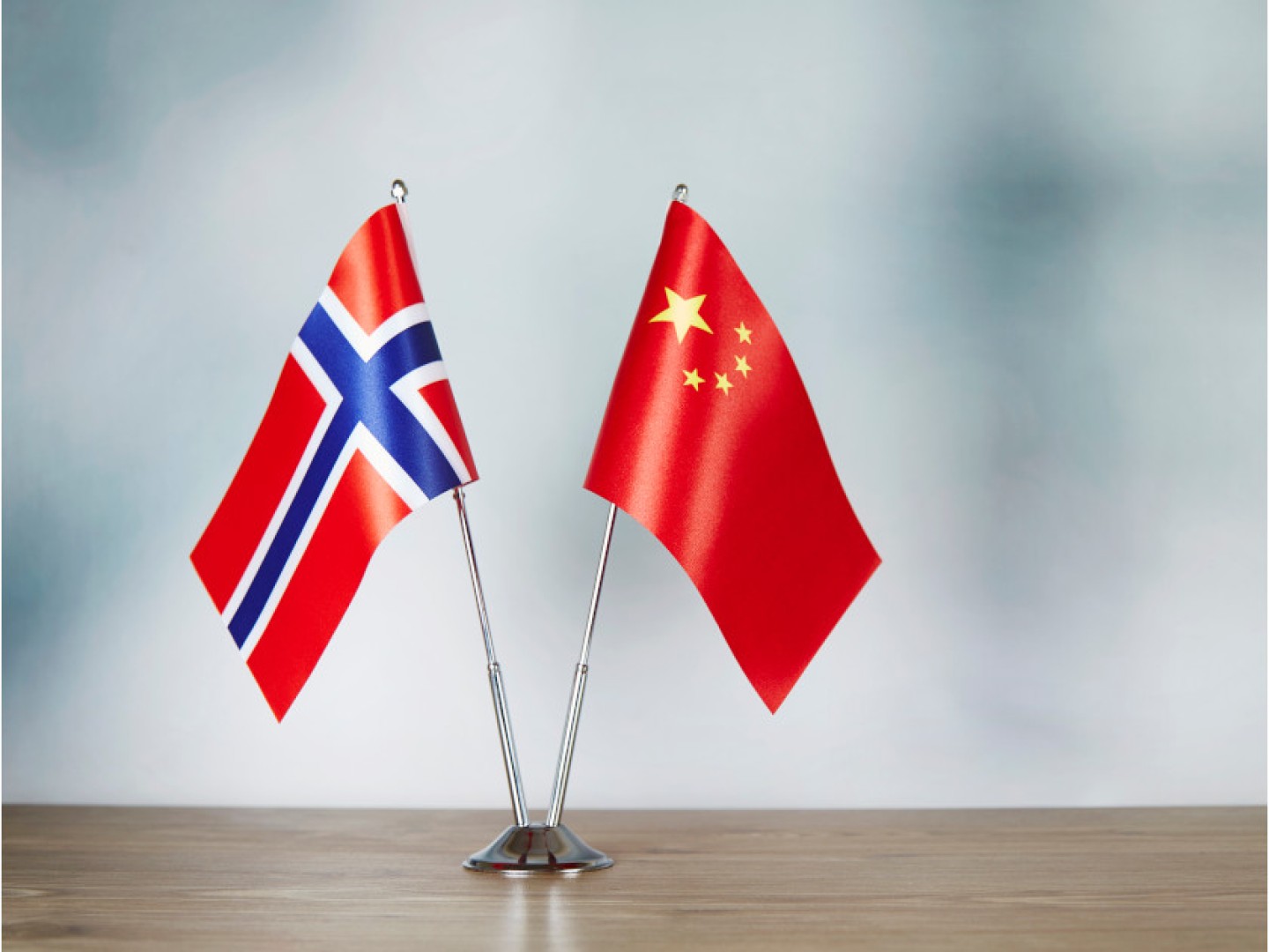 Norwegian and Chinese flags in a stand together on a table.