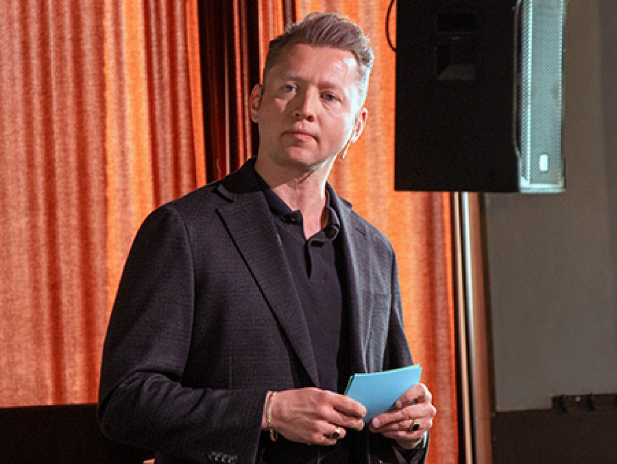 Magnus Thomassen står på en scene og holder foredrag om den norske musikkbransjen.