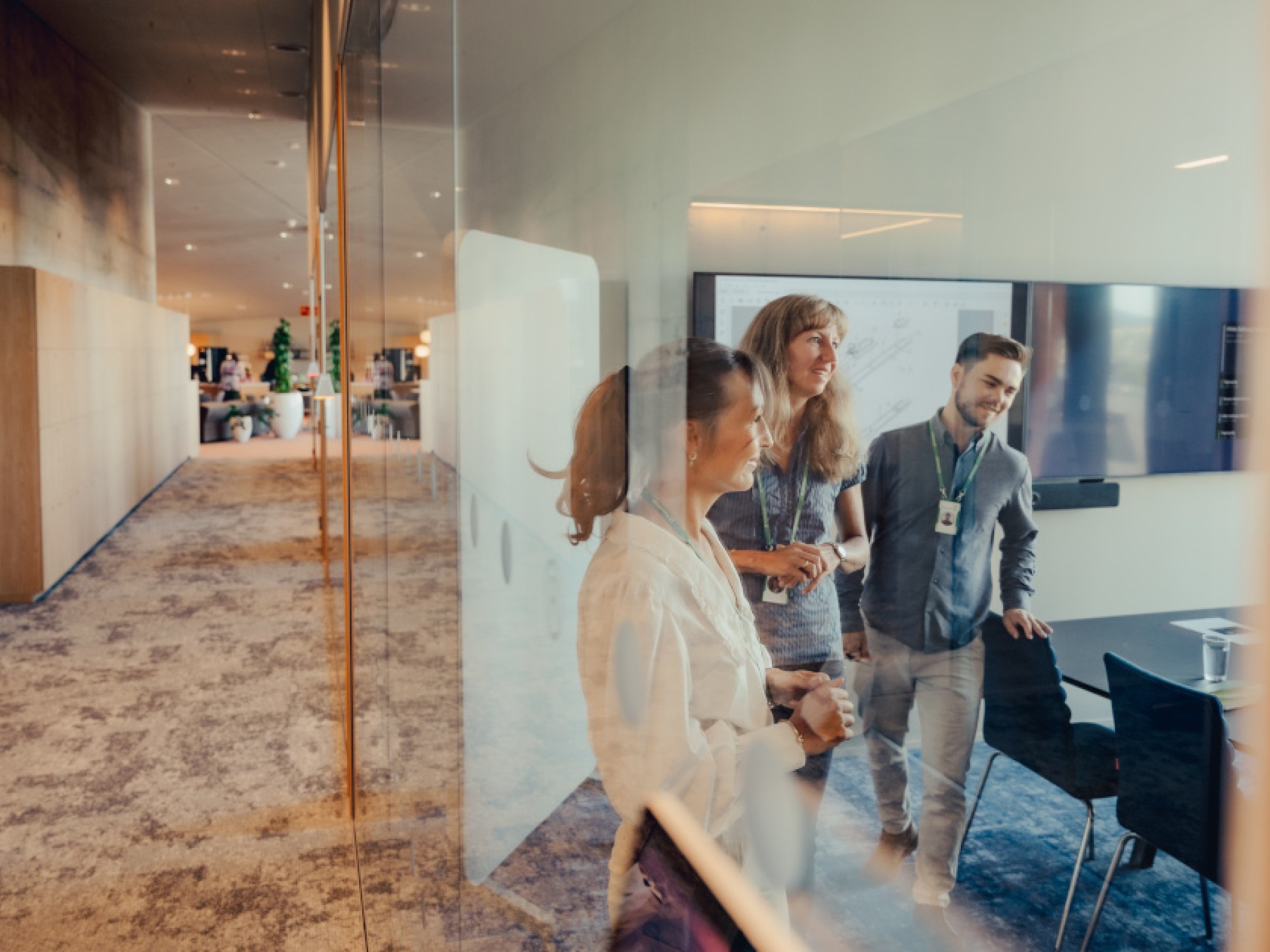 Ansatte snakker sammen i et møterom i Patentstyrets lokaler.